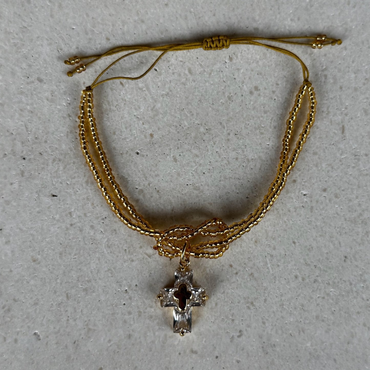 Pulsera protección de nudo dorada/cruz